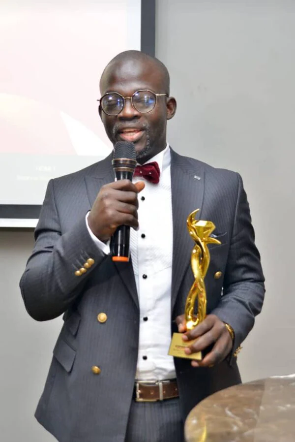 Dr. Stephen Adetutu Oniya speaks while holding the technology company award.